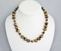 "This necklace showcases the contrasting bands of color and lustre in the large golden brown tiger eye beads in two sizes and separated with polished 14K gold filled accent beads. It is finished with a gold filled spring ring and attached 2.5\" gold filled adjustable chain. The necklace can be worn between 17.5 inches and 20 inches in length (44 to 51 cm). This is a timeless necklace that is easily worn with black, cream, white, brown, and gold blouses or sweaters--a very versatile piece! It shi Brown Gemstone Beaded Necklace, Brown Single Strand Jewelry As A Gift, Brown Single Strand Jewelry For Gifts, Brown Single Strand Jewelry Gift, Brown Single Strand Round Bead Jewelry, Brown Gemstone Jewelry With Round Beads, Brown Polished Beads Jewelry Gift, Brown Gemstone Necklaces With Round Beads, Spiritual Brown Single Strand Jewelry