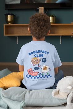 Breakfast Club Toddler Tshirt, Kids Retro Vintage Tshirt. This T-shirt is 100% Cotton and has a 2-Part design on the front and back featuring pancakes, bacon and eggs! Order a size or two up for an Oversized look. For the adult sizes please check out: https://www.etsy.com/uk/listing/1674601835/breakfast-club-aesthetic-bohemian-retro NOTE TO OUR CUSTOMERS We are a new business and very much appreciate your support! If you love your Tee as much as we hope you do, please leave us a review, thank yo Blue Family Matching T-shirt With Cartoon Print, Family Matching Blue T-shirt With Cartoon Print, Funny Cotton T-shirt With Cartoon Print, Family Matching Cotton Graphic T-shirt, Playful Cartoon Print Crew Neck T-shirt, Blue Family Matching Tops With Funny Print, Playful Crew Neck T-shirt With Cartoon Print, Blue Tops With Funny Print For Family Matching, Family Matching Short Sleeve Pre-shrunk T-shirt