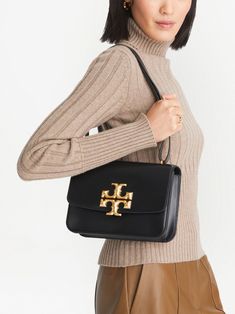 Find TORY BURCH Eleanor Shoulder Bag on Editorialist. The Tory Burch Eleanor shoulder bag is crafted from calf leather and features a gold-tone logo plaque. It has a single shoulder strap, a foldover top, a main compartment, and an internal zip-fastening pocket. The bag can be worn on the shoulder or crossbody. Tory Burch Eleanor Bag, Tory Burch Shoulder Bag, Tory Burch Bag, Small Bags, Leather Shoulder Bag, Calf Leather, Neiman Marcus, Bags Women, Tory Burch