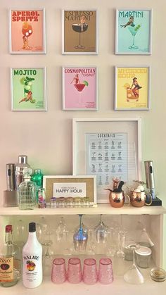 a shelf with bottles and glasses on it next to framed pictures above the bar area