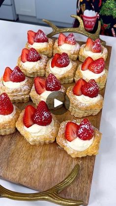 small pastries with strawberries on a wooden platter next to a deer antlers head