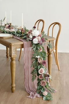 a long table with flowers and candles on it, next to two chairs in front of the table