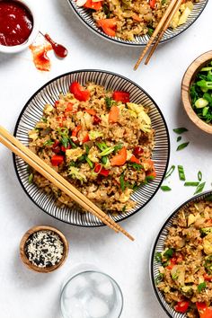 three plates filled with rice and vegetables next to chopsticks