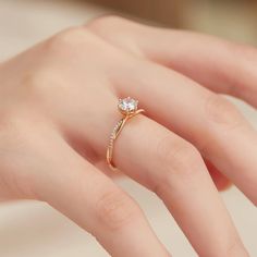 a woman's hand with a diamond ring on top of her finger and an engagement band