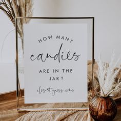 a sign that says how many candles are in the jar? next to some dried plants