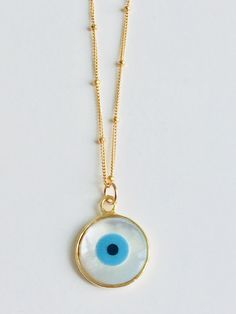 "Shell Evil Eye Necklace. This is a Shell evil eye necklace on a 16\" inch satellite chain. The white of the pendant reminds me of the white washed walls of buildings on the Greek islands. The evil eye is said to protect it's wearer from evil. Be it bad people or dangerous situations. I love mine and wear it often. 💫💫" White Evil Eye Round Pendant Necklace, White Round Pendant Necklace With Evil Eye, White Spiritual Charm Necklace With Round Pendant, Spiritual White Charm Necklace With Round Pendant, White Evil Eye Jewelry, White Spiritual Round Pendant Charm Necklace, White Necklace With Lobster Clasp And Round Pendant, White Round Pendant Necklace With Lobster Clasp, White Necklace With Round Pendant And Lobster Clasp