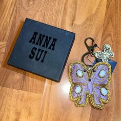 a book and keychain sitting on top of a wooden floor next to a pair of scissors