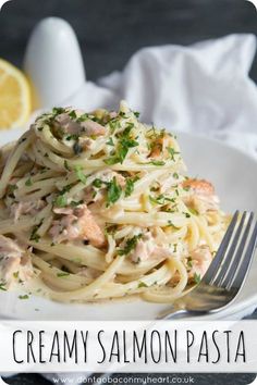 a white plate topped with pasta covered in cream sauce