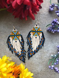 the beaded earrings are on display next to flowers