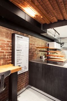 the interior of a restaurant with brick walls and exposed ceilings, along with a menu