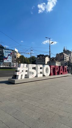 a large sign that says beo paa on the side of a road with buildings in the background