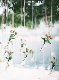 hanging vases filled with pink flowers and greenery