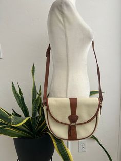 Super cute, cream colored pebbled leather with brown trim, cross-body handbag with adjustable strap. Bag is lined in plaid, has one inner zippered pocket, one open pocket in the front, and a snap closure in the front. In overall great vintage condition with no major flaws, although there are a couple spots on the back and side with a bit of blue transference, only noticeable when closely inspecting. Logo, placket and hardware all say Guess. Dimensions Height 9in/23cm Across 11in/28cm (at the top) Width 3.5in/9cm Strap 51in/129.5cm (longest) *Please keep in mind that unless otherwise noted, all items in my shop are used or previously owned, normal wear and tear is expected, flaws that are noted are range from major to minor, things like a missing stitch here or there my not be included. *Pl Cream Crossbody Shoulder Bag For Travel, Cream Shoulder Bag With Leather Trim, Classic Shoulder Bag With Snap Closure For Errands, Cream Leather Bag For Fall, Classic Crossbody Satchel With Leather Trim, Classic Leather Trim Crossbody Satchel, White Leather Trim Crossbody Shoulder Bag, White Shoulder Bag With Adjustable Strap For Fall, Retro White Leather Shoulder Bag