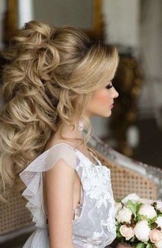 a woman in a white dress holding a bouquet and looking off into the distance with long hair