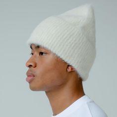 a young man wearing a white knitted hat