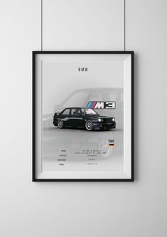 a black car with bmw on the back in a white frame hanging on a wall