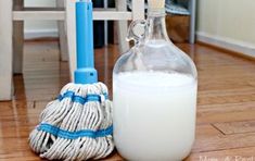 a bottle of milk next to a mop on the floor