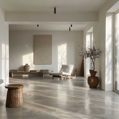 an empty living room with large windows and wooden furniture on the floor in front of them