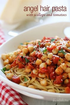 a white bowl filled with pasta covered in sauce and garnished with chickpeas