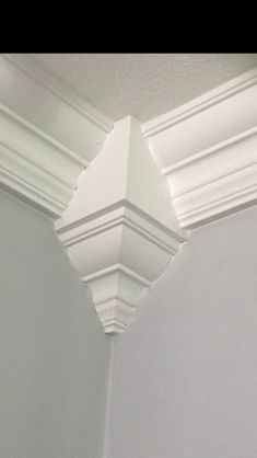 the corner of a room with white molding on the wall and ceiling above it