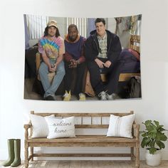 three men sitting on a bench in front of a wall with the words welcome home