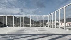 an empty basketball court surrounded by metal bars