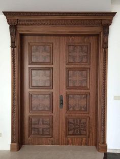 a large wooden door with decorative carvings on the front and side panels inlays