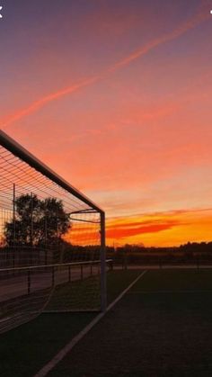 the sun is setting behind a soccer goal