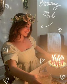 a woman sitting in front of a cake with candles on it