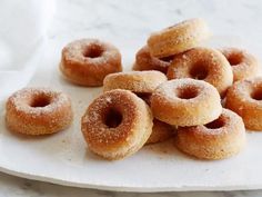 several sugared doughnuts on a white plate