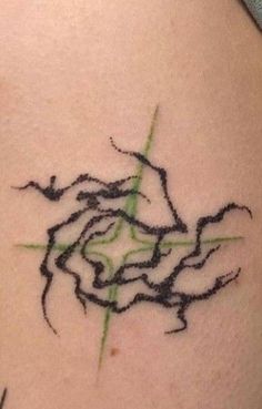 a tattoo on the back of a woman's shoulder that has green lines coming out of it