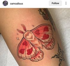 a red and white butterfly tattoo on the thigh, with hearts in it's wings