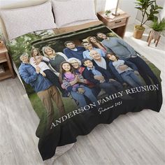 a bed with a family photo on it and two pillows in front of the comforter