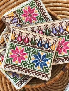 three small purses sitting on top of a wicker basket