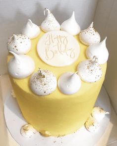 a yellow cake with white frosting and gold sprinkles