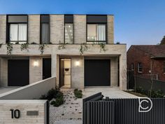 a modern house with black doors and windows on the outside, surrounded by brick walls