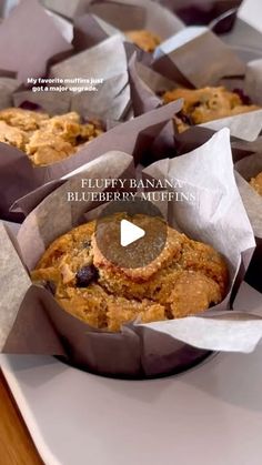 several muffins in paper cups sitting on top of a wooden table with the words fluffy banana blueberry muffins