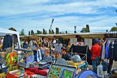 many people are shopping at an outdoor flea market