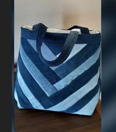 a blue and white striped bag sitting on top of a wooden table next to a wall