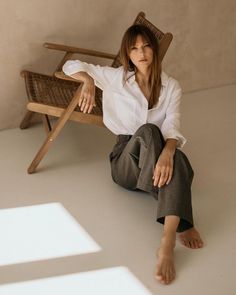 a woman sitting in a chair with her legs crossed and one foot on the ground