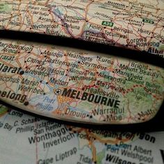 a magnifying glass sitting on top of a map next to it's reflection