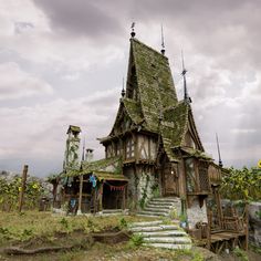 an old house with moss growing on it's roof and stairs leading up to the front door