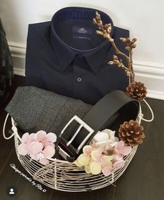 there is a basket with flowers in it and a shirt on the table next to it