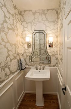 a white sink sitting under a bathroom mirror next to a wall mounted faucet