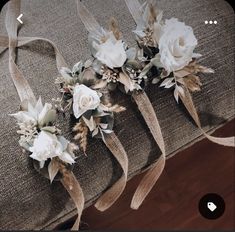 three bouquets of flowers sit on top of a couch with ribbons tied around them