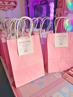 pink shopping bags are sitting on a table