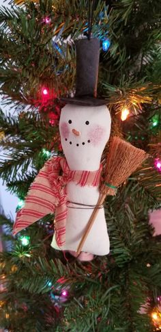 a snowman ornament hanging from a christmas tree