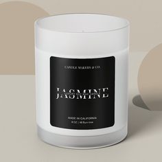 a candle that is sitting on a table next to a wall with the words jammine jasmine printed on it