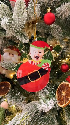 a christmas ornament hanging from the top of a tree with ornaments around it