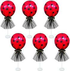 six red and black ladybug balloons on top of each other, with white polka dots